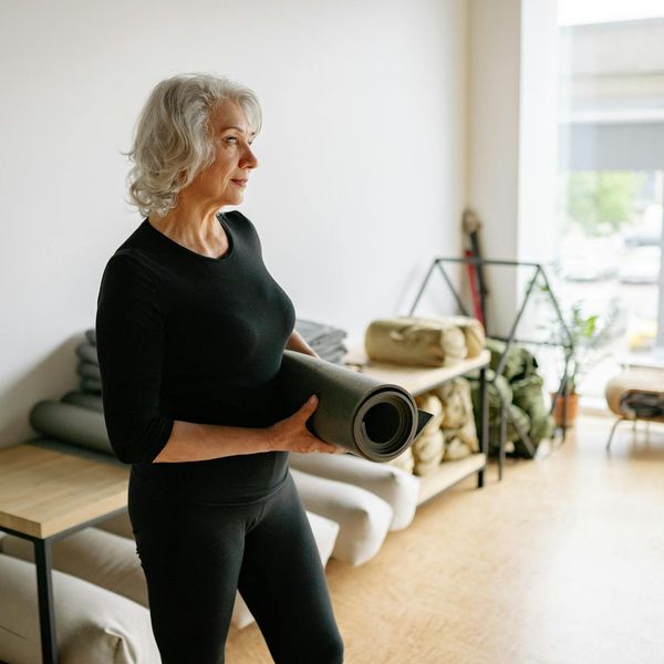 Person meditating peacefully in a bright, minimalist room.