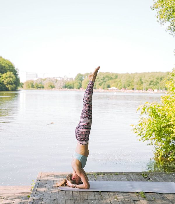 Woman in a calm yoga pose in a dark, serene environment.